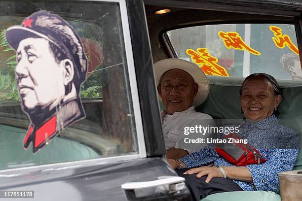 Two old people sit in the car show at the 798 Art Exhibition Commemorating CPC'S 90th Anniversary on July 1, 2011 in Beijing, China. This year's...