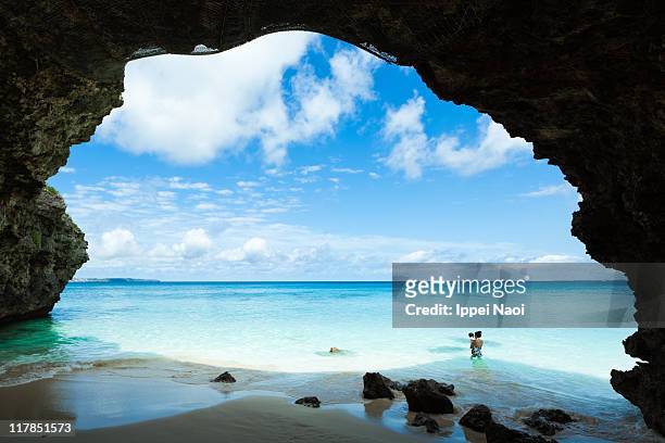 crystal clear lagoon water beach with arch, japan - okinawa prefecture stock pictures, royalty-free photos & images