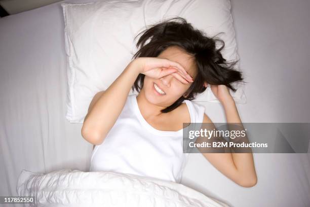woman waking up in bed - rubbing eyes stock pictures, royalty-free photos & images