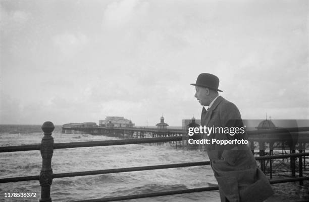 Scottish comedian Charlie Naughton takes a walk on the front above the beach in Blackpool, England during World War II in November 1940.