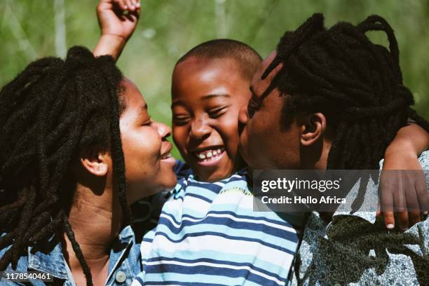 happy boy being showered with affection by parents - african ethnicity family africa stock pictures, royalty-free photos & images