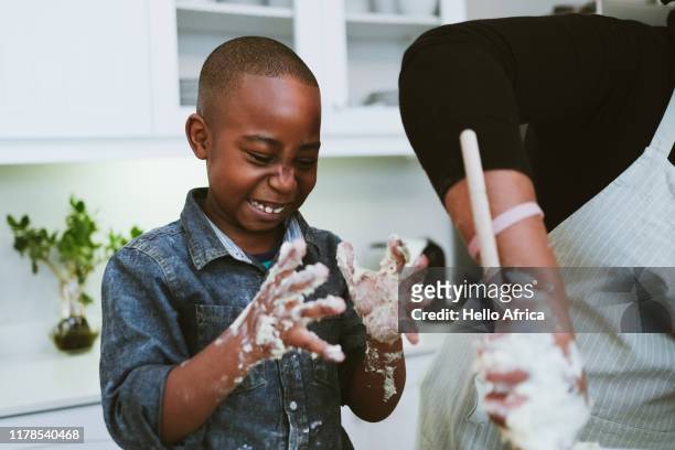 happy boy with sticky dough hands - baking stock pictures, royalty-free photos & images