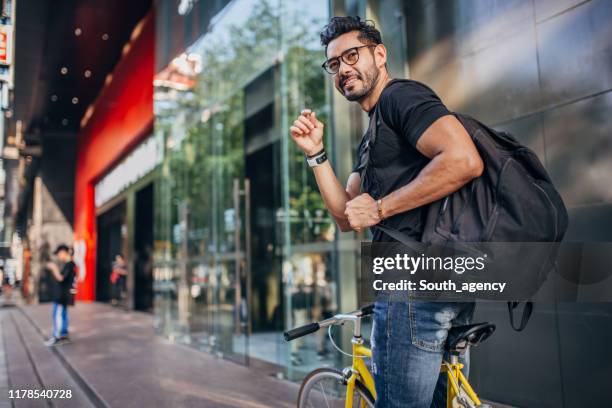 stilig man ridning cykel i staden - suave bildbanksfoton och bilder