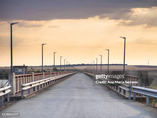 rural road over a bridge, with railing and guardrails at sunset - meta turistica fotografías e imágenes de stock