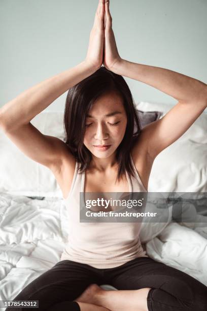 kinesisk kvinna som gör yoga i sängen - daily sport girls bildbanksfoton och bilder