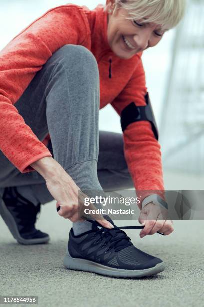 onherkenbaar senior persoon het binden van schoenveters op sport sneakers - old lady feet stockfoto's en -beelden