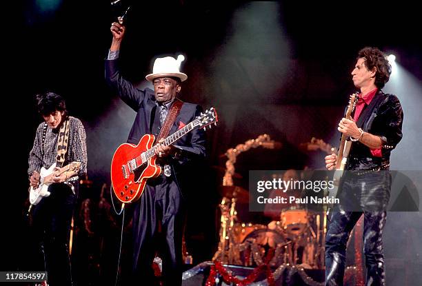 American musician John Lee Hooker performs onstage with British musicians Ron Wood , Charlie Watts , and Keith Richards, all of the rock and roll...