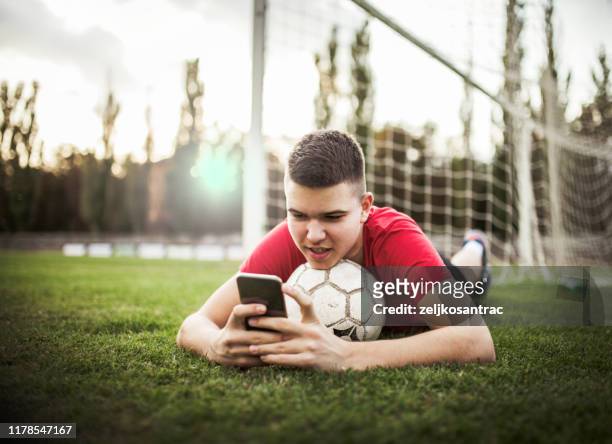 boy soccer player using cellphone - football phone stock pictures, royalty-free photos & images