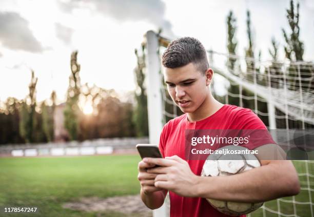 boy soccer player using cellphone - football phone stock pictures, royalty-free photos & images