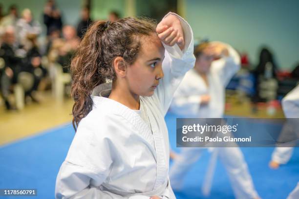 sports and disciplines. martial arts. pre-teen girl during a karate class in gym - child judo stock pictures, royalty-free photos & images