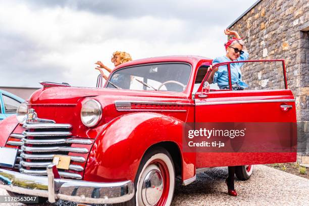 two pin up girls standing by the vintage car stock photo - rockabilly pin up girls stock pictures, royalty-free photos & images