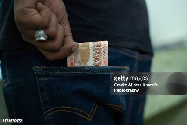 putting money in pocket - pakistan currency stock pictures, royalty-free photos & images