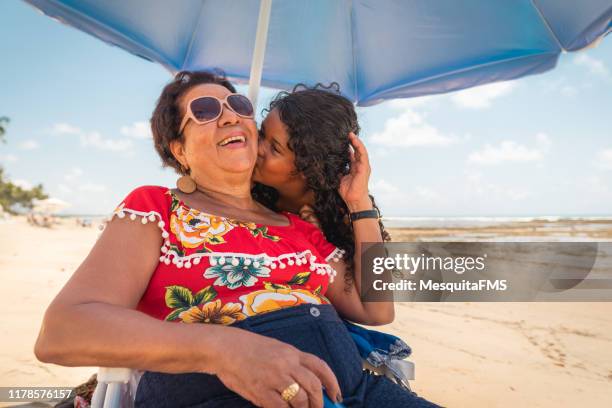 mädchen küssen oma und genießen den tropischen strand - hispanic man on beach stock-fotos und bilder