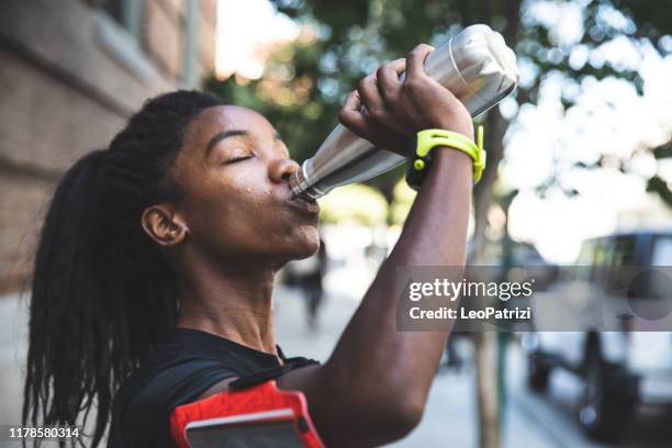 mujer afroamericana con rastas en una gran forma atlética haciendo ejercicio y entrenando duro al aire libre - black pants woman fotografías e imágenes de stock