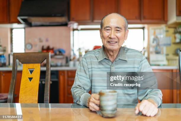 portrait of happy senior man at home - content japanese ethnicity stock pictures, royalty-free photos & images