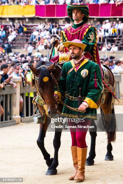 at the palio, a bareback horserace, dating back to the 16th century, held twice each summer in piazza del campo, siena. at the corteo storico, the pre-race pageant, riders in traditional costume parade with their horses, aug 2019, siena, tuscany, italy - palio di siena stock pictures, royalty-free photos & images