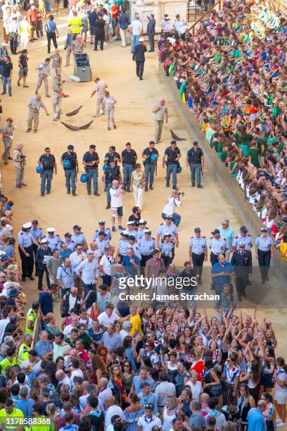 crowds watch the track around the main square (medieval piazza del campo) being cleared at the dress rehearsal (prova generale) of the palio horserace, siena, tuscany, italy august 2019 - prova generale stock pictures, royalty-free photos & images
