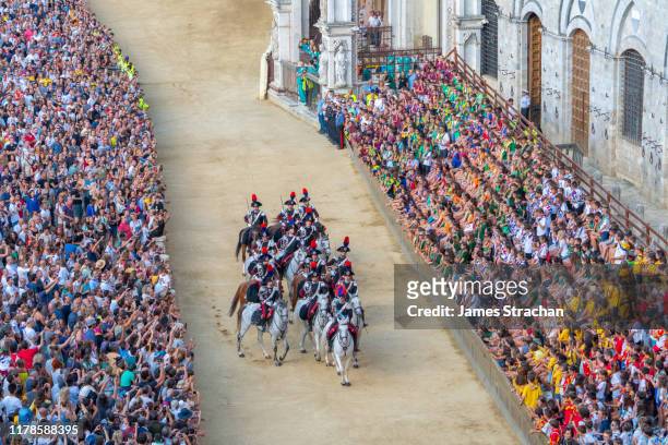 carabinieri (police) on horseback parade around the main square (medieval piazza del campo) at the dress rehearsal (prova generale) of the palio horserace, siena, tuscany, italy august 2019 - prova generale stockfoto's en -beelden