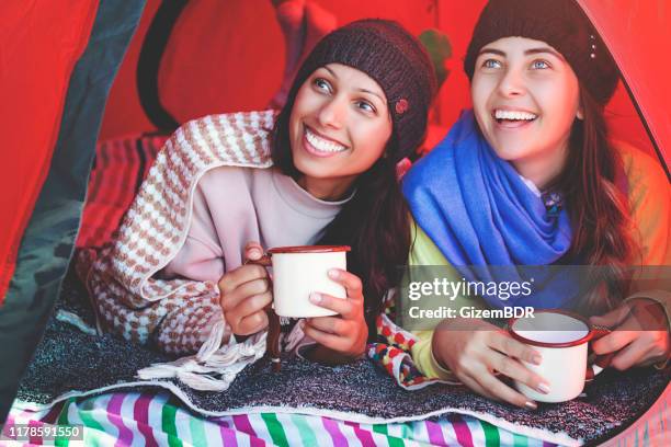 zwei junge mädchen genießen kaffee im zelt - emaille stock-fotos und bilder