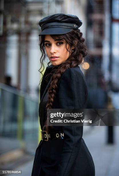 American singer Camila Cabello is seen wearing black belted dress Ronald van der Kemp, flat cap on October 02, 2019 in London, England.