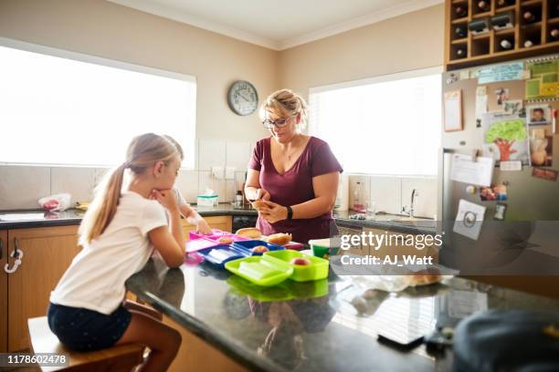 ze maakt school lunchbox voor kinderen - boy packlunch stockfoto's en -beelden