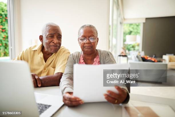 checking their monthly bills - examining paperwork stock pictures, royalty-free photos & images