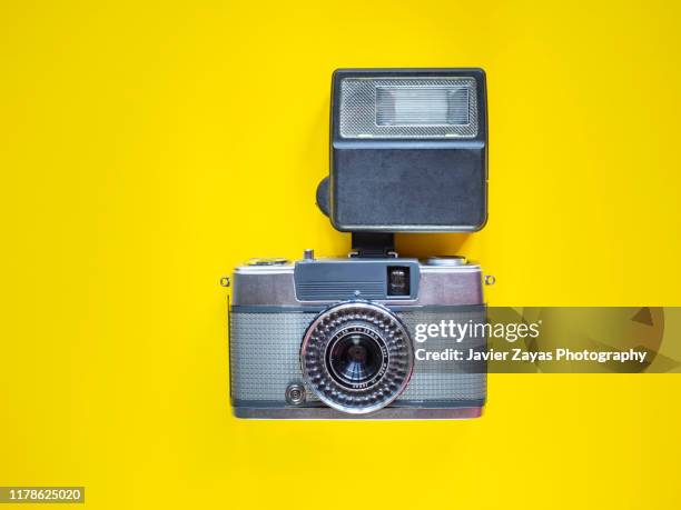 directly above view of retro vintage camera and speedflash on yellow background - maquina fotografica antiga imagens e fotografias de stock