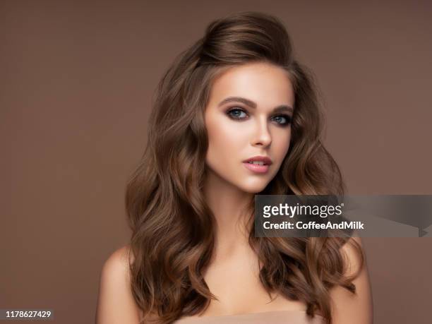 junge schöne modell mit langen welligen gepflegten haaren - wavy hair stock-fotos und bilder