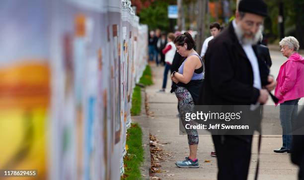 Visitors look at inspired artworks along the fence at the Tree of Life Synagogue on the 1st Anniversary of the attack on October 27, 2019 in...