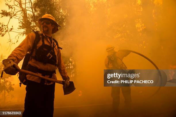 Firefighters battle the Kincade Fire along Chalk Hill Road in Healdsburg, California on October 27, 2019. - Powerful winds were fanning wildfires in...