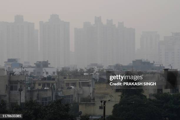 Residential buildings are pictured in heavy smog conditions in Ghaziabad on the outskirts of New Delhi on October 28, 2019. - Air quality in the...