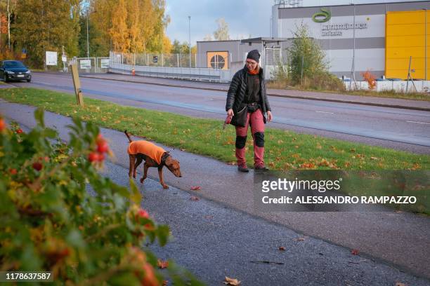 Marianne Mayer, dog trainer and promoter of a campaign that aims to give dog poo a new life, takes a walk with one of her dogs in Vantaa, Finland on...