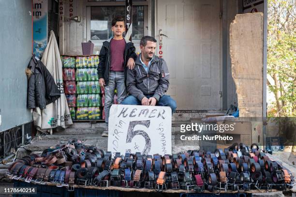 On Oct. 27 a father and son sell belts as citizens of the Turkish capital city, Ankara, went shopping in bazaars and markets, buying food and...