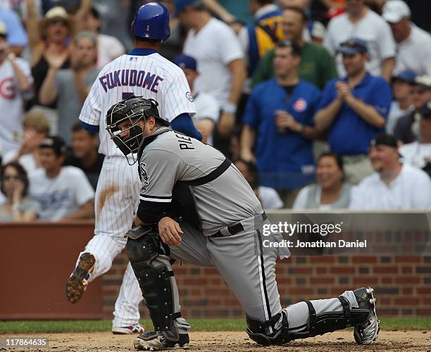 Pierzynski of the Chicago White Sox kneels and watches as Kosuke Fukudome of the Chicago Cubs scores a run in the 3rd inning at Wrigley Field on July...