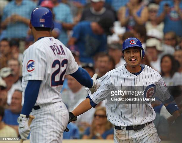 Darwin Barney of the Chicago Cubs is congratulated by teammate Carlos Pena after scoring a run in the 3rd inning against the Chicago White Sox at...
