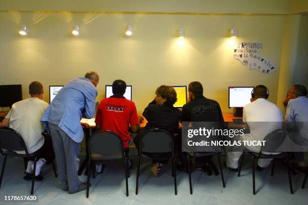 Des détenus participent avec des tuteurs-accompagnateurs à un atelier collectif à l'espace Cyber-base Justice de la maison d'arrêt de...