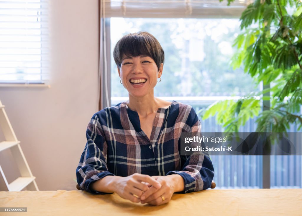 食堂に座っている日本人の母親の肖像