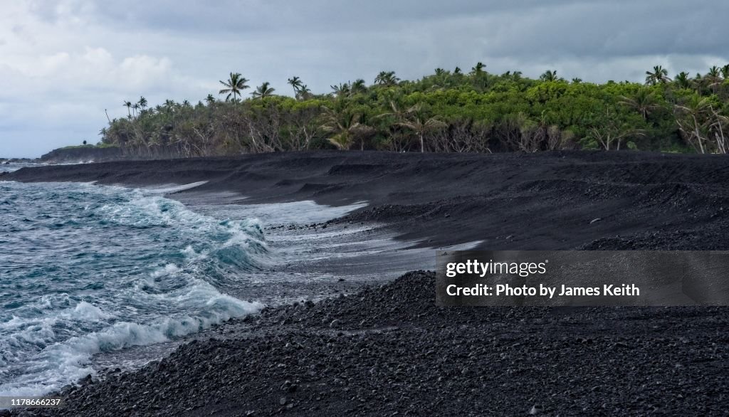 Wave action slowly erodes Hawaii's newest black sand beach.