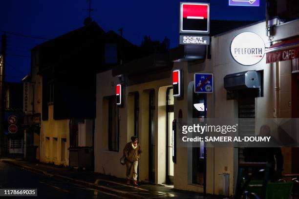 Woman walks in front of the Societe Generale bank in Ouistreham, Normandy, northwestern France, on October 28, 2019.