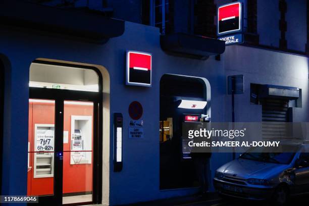 Man uses the cash machine of a Societe Generale bank, in Ouistreham, Normandy, northwestern France, on October 28, 2019.