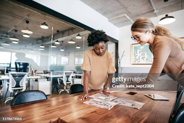 zwei geschäftsfrau arbeitet in einem interessanten projekt zusammen - art director stock-fotos und bilder