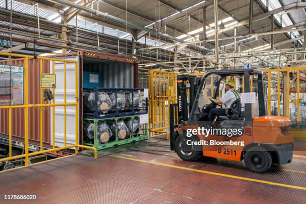An employee uses a fork lift to load the engines into a container truck at the Sunter 1 Plant, an engine manufacturing facility operated by PT Toyota...