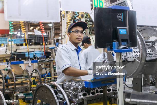 An employee performs a quality check on an engine part at the Sunter 1 Plant, an engine manufacturing facility operated by PT Toyota Motor...