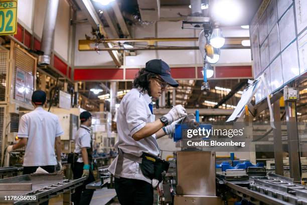 An employee performs a quality check on an engine part at the Sunter 1 Plant, an engine manufacturing facility operated by PT Toyota Motor...