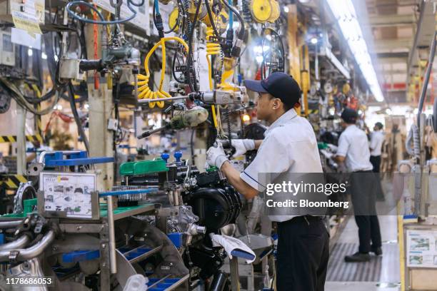 An employee works on an engine at the Sunter 1 Plant, an engine manufacturing facility operated by PT Toyota Motor Manufacturing Indonesia , a...