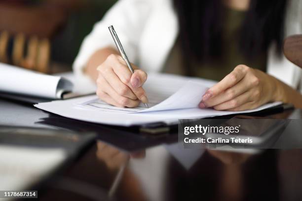 hands signing contract - woman signing stock pictures, royalty-free photos & images