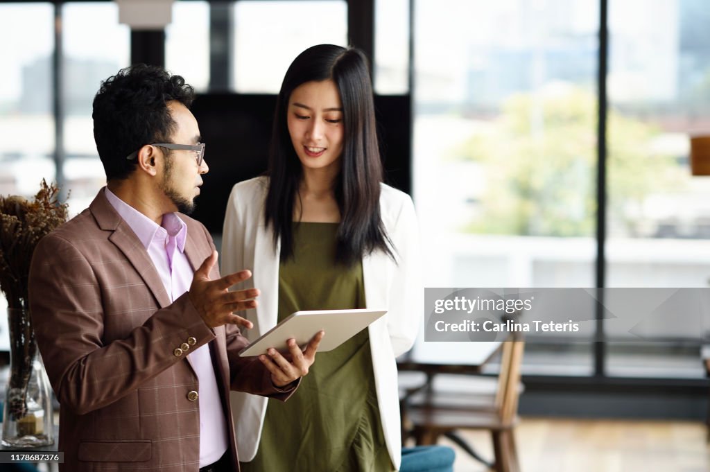 Colleagues working from a tablet in an office together