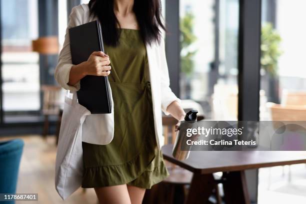 woman walking out of an office with laptop - reusable water bottle office stock pictures, royalty-free photos & images