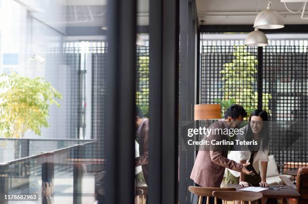 colleauges working together in an office - indonesian ethnicity stock-fotos und bilder