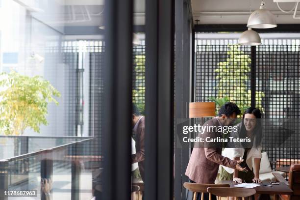colleauges working together in an office - singapore office stock pictures, royalty-free photos & images